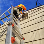 A worker at the top of a ladder